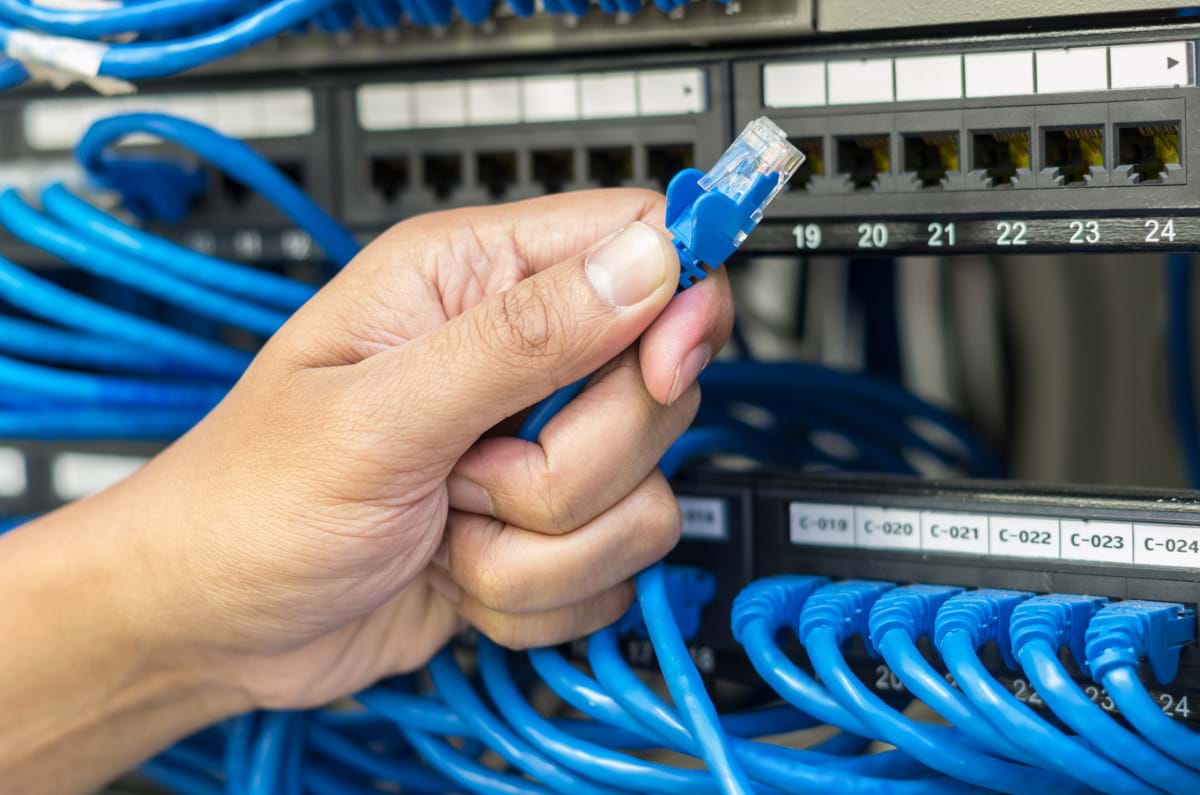 Hand holding cable in front of a server